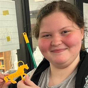 student holding keychain created from 3D printer