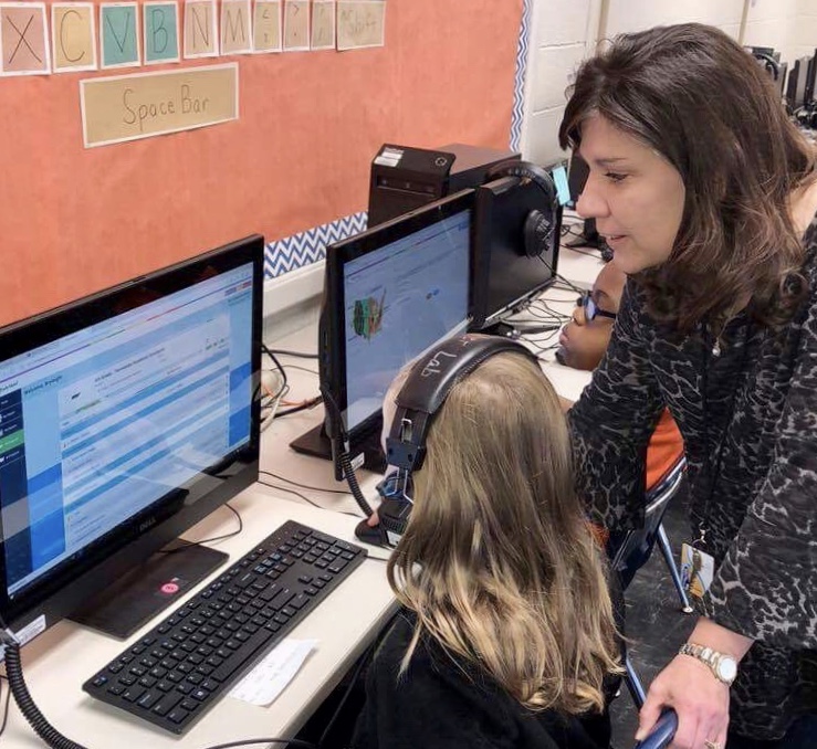 Ms. Butler assists an East Elementary student during computer class